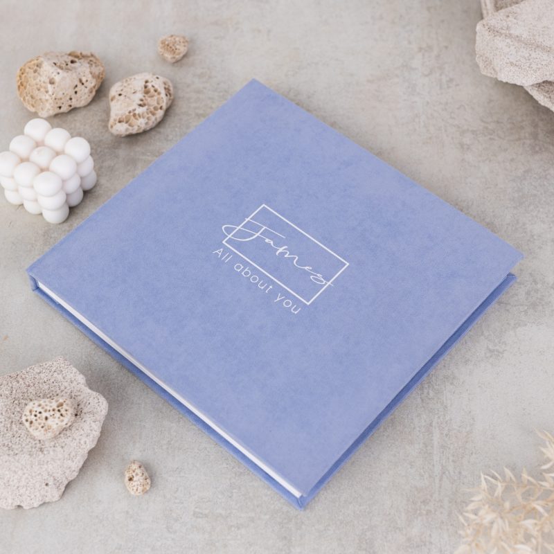 Minimalist baby memory book with fabric cover and customizable details.